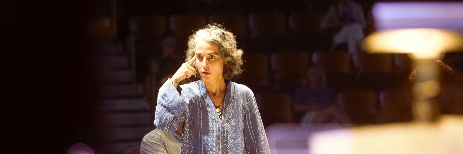 Clarice Assad in rehearsal, one finger to her temple, listening